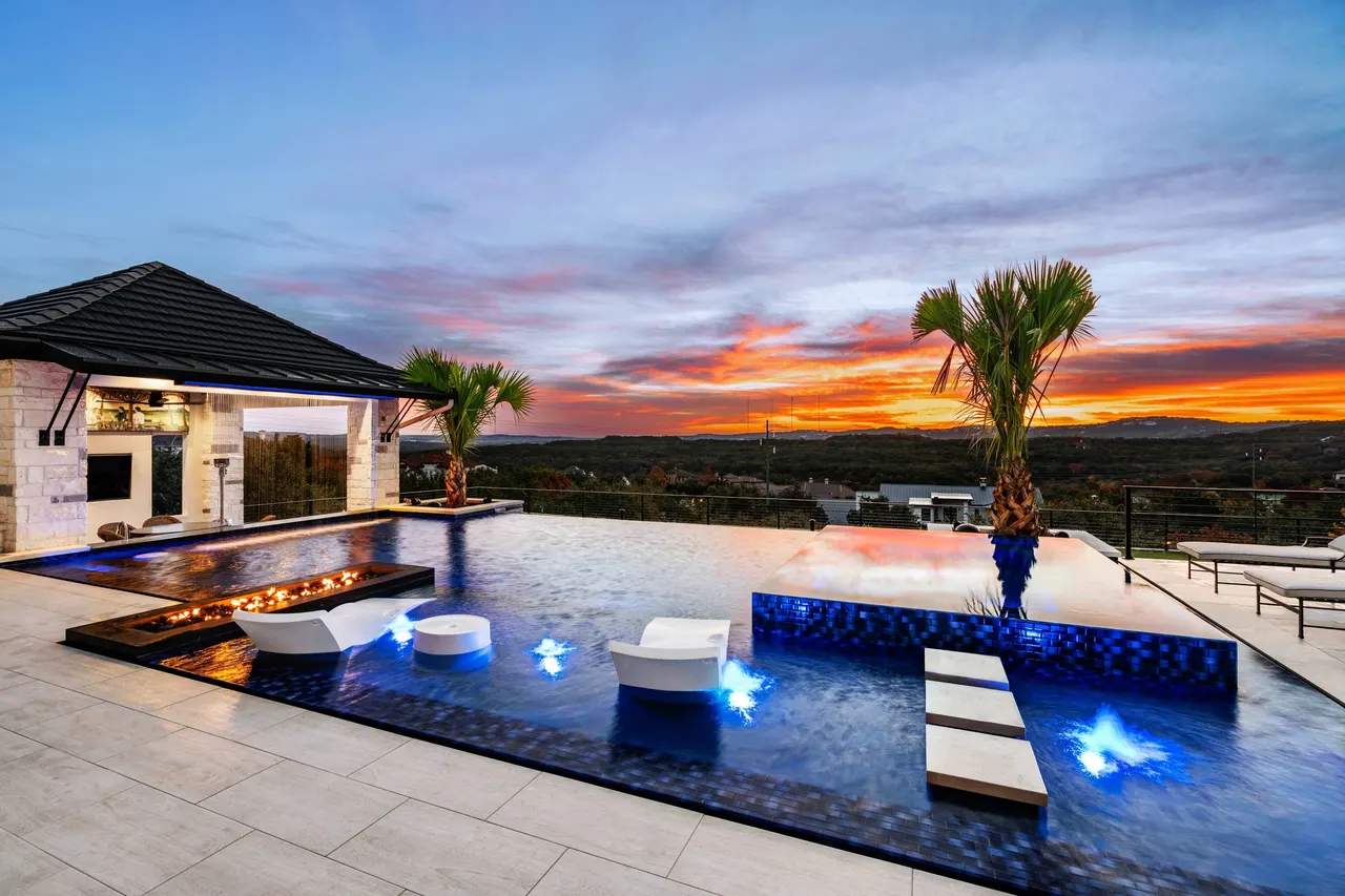 The same terrace a few minutes earlier: fire trough lit, in-water loungers, the sky going orange