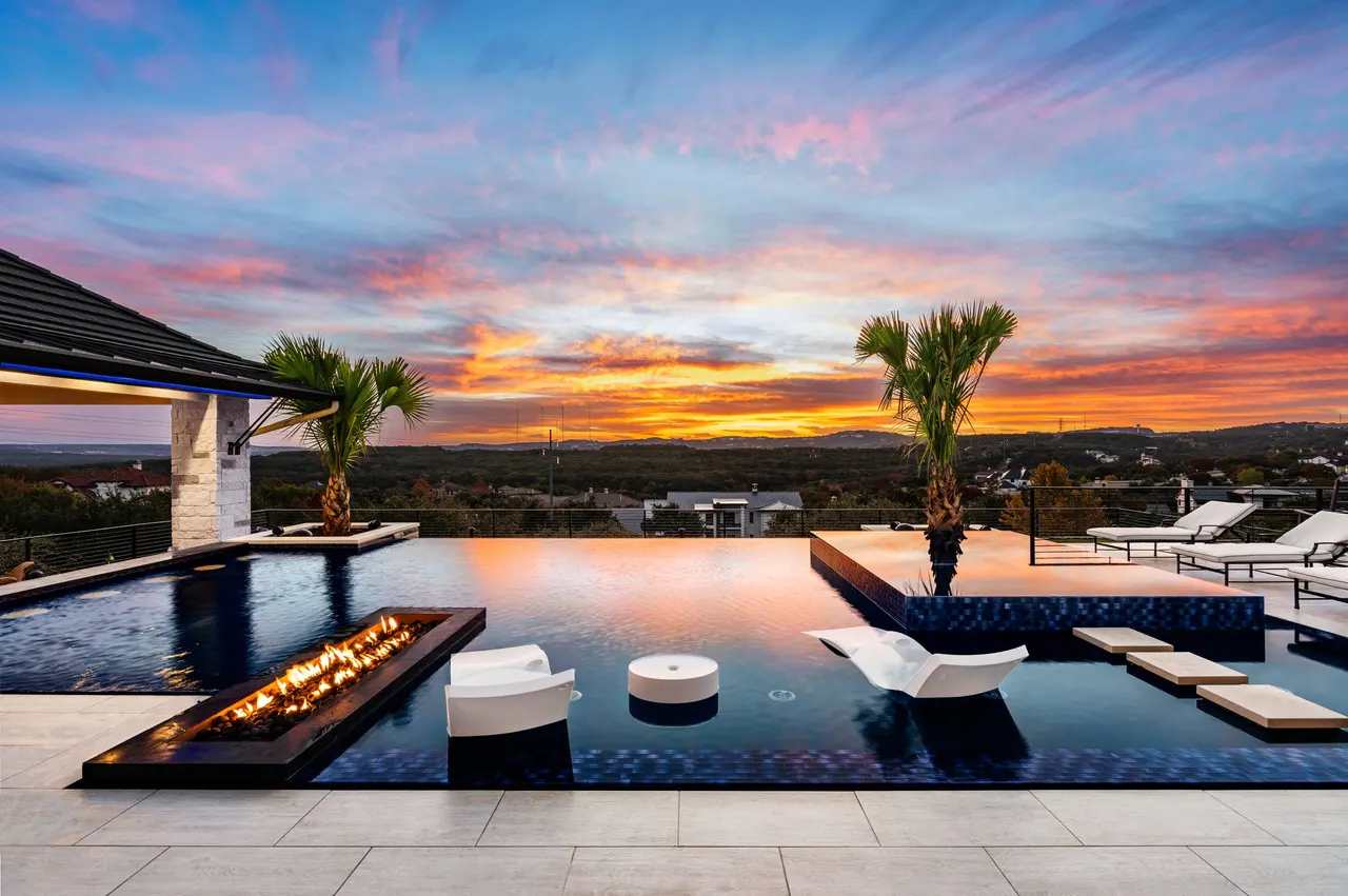 Perimeter-overflow pool and raised spa at sunset on a Hill Country ridge in Bee Cave — Cliffside Overflow by GB IV Designs