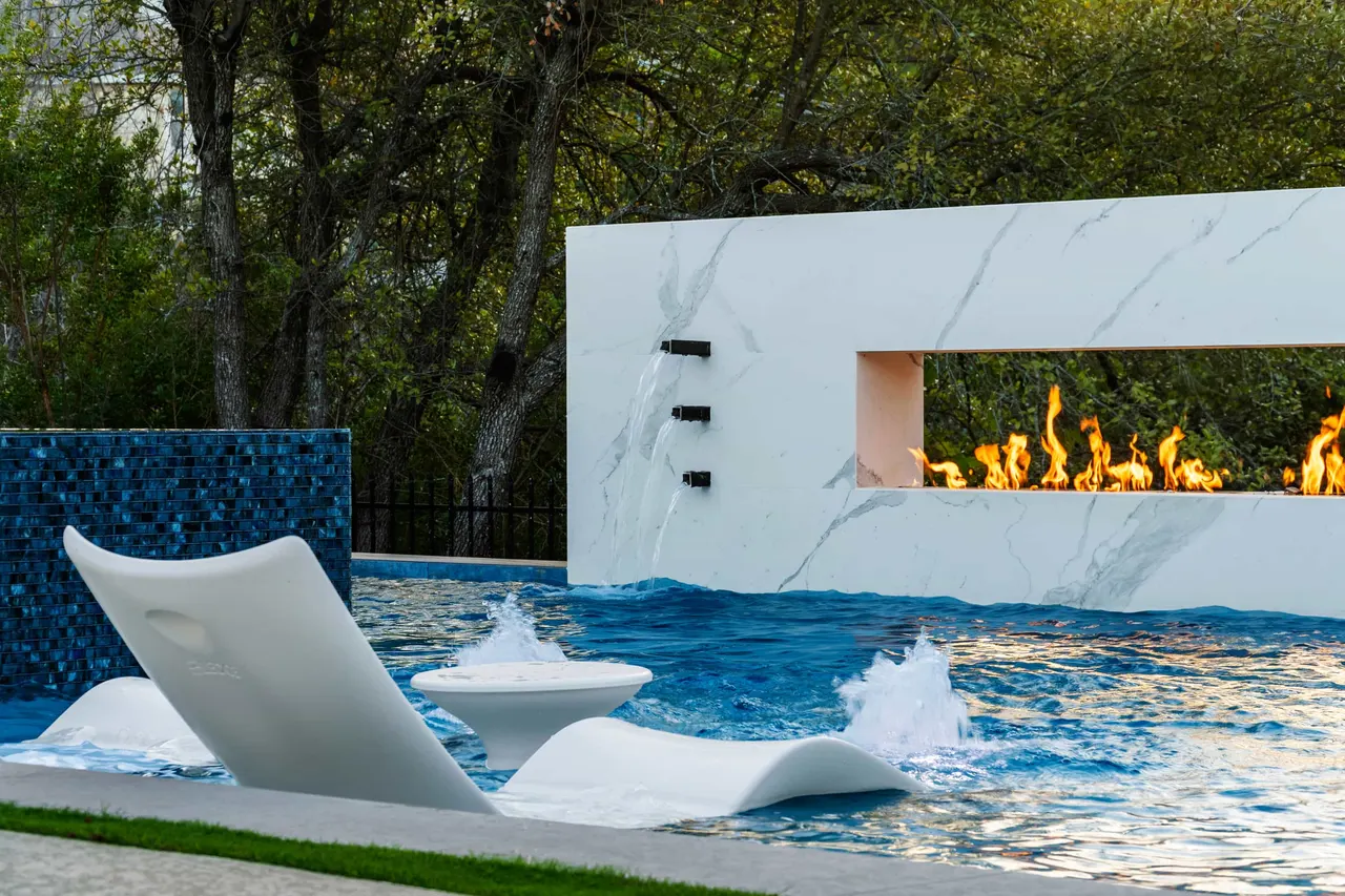 In-water loungers on a raised linear pool with a dark glass-tile face — Courtyard Linear, Tarrytown